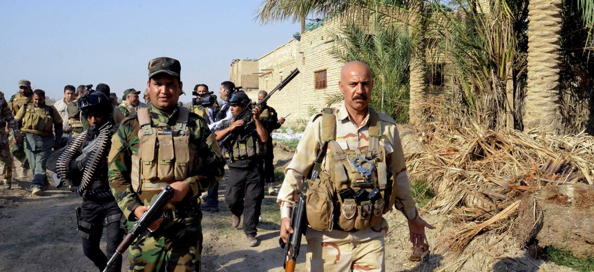 Iraqi security forces and Shiite militia men patrol Jurf al-Sakhar, 43 miles south of Baghdad, Iraq, on October 26, 2014.
