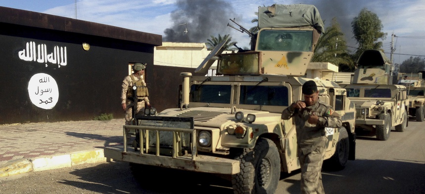 Iraqi army soldiers deploy in front of a court run by the Islamic State group after a military operation to regain control of the town of Sadiyah in Diyala province, 60 miles north of Baghdad, Iraq.