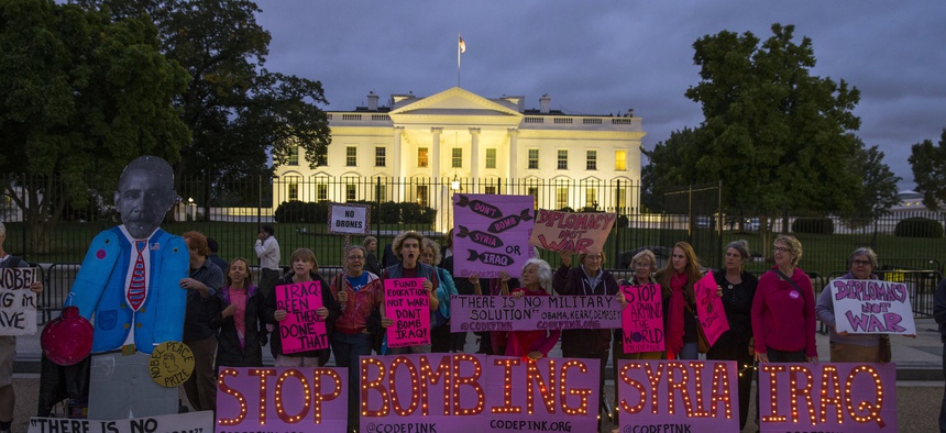 Demonstrators stand outside the White House to protest air strikes on targets in Iraq and Syria, on Thursday, Sept. 25, 2014.