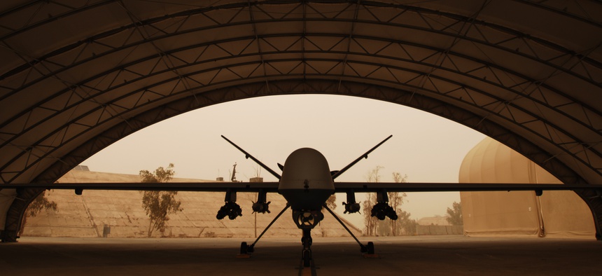 An MQ-9 Reaper in Iraq waits out a sandstorm beneath a shelter in 2008.
