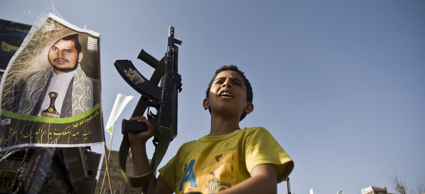 A boy holds a weapon while Shiite rebels known as Houthis protest against Saudi-led airstrikes, during a rally in Sanaa, Yemen, Wednesday, April 1, 2015.