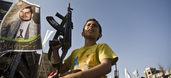 A boy holds a weapon while Shiite rebels known as Houthis protest against Saudi-led airstrikes, during a rally in Sanaa, Yemen, Wednesday, April 1, 2015.