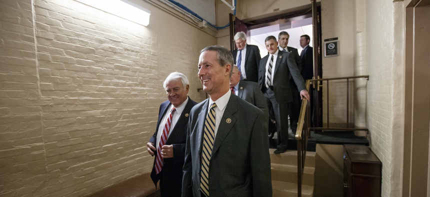 Rep. Mac Thornberry, R-Texas, center, and other House Republicans emerge from a closed-door meeting in the basement of the Capitol on how to deal with the impasse over the Homeland Security budget, in Washington, Thursday night, Feb. 26, 2015.