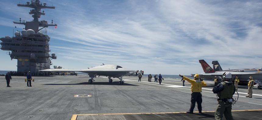 An X-47B Unmanned Combat Air System (UCAS) demonstrator taxies on the flight deck of the aircraft carrier USS George H.W. Bush (CVN 77).