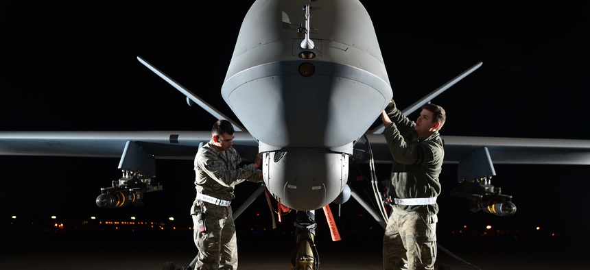Airman 1st Class Steven (left) and Airman 1st Class Taylor prepare an MQ-9 Reaper for flight during exercise Combat Hammer, May 15, 2014, at Creech Air Force Base, Nev.
