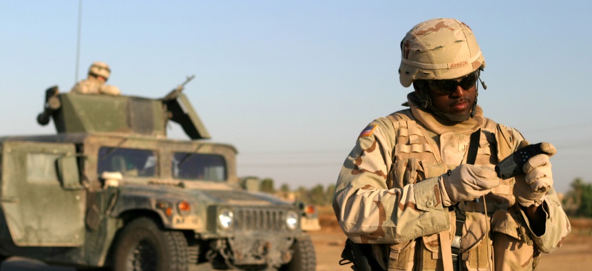 U.S. Army Staff Sgt. Lorenzo Johnson examines his Global Positioning System receiver during a route reconnaissance patrol of Alternate Supply Route Boston in Iraq.