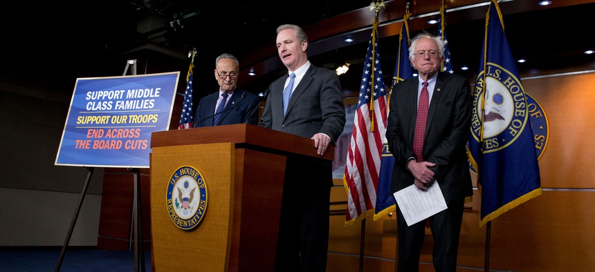 Rep. Chris Van Hollen, D-Md.,, center, flanked by Sen. Bernie Sanders, I-Vt., right, and Sen. Charles Schumer, D-N.Y., speaks during a news conference on Capitol Hill in Washington, Wednesday, April 29, 2015, to speak out against the Republican budget.