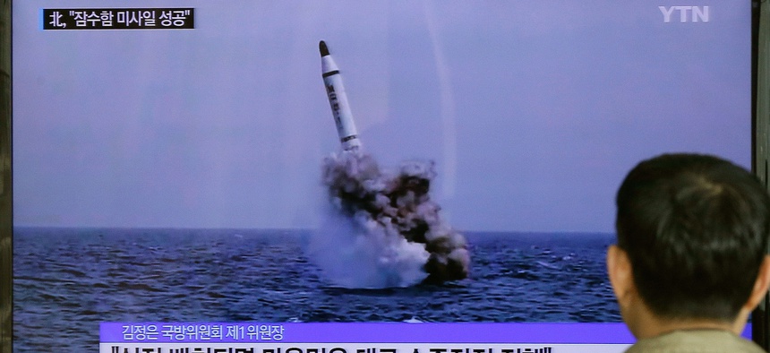 A South Korean man watches a TV news program showing North Korea's ballistic missile believed to have been launched from underwater, Saturday, May 9, 2015.