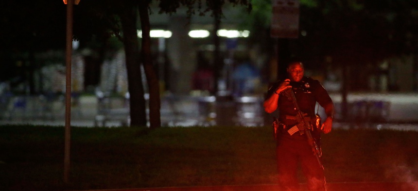 An armed police officer stands guard at a parking lot near the Curtis Culwell Center where a provocative contest for cartoon depictions of the Prophet Muhammad was held May 3, 2015, in Garland, Texas.