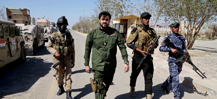 Members of Iraq's Sunni tribes walk at the front line during a battle with ISIS militants in Tikrit, Iraq, on March 16, 2015.