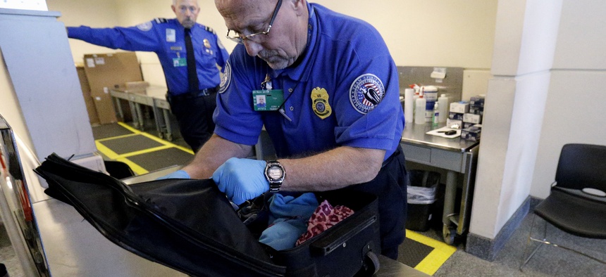 A TSA agent checks a bag at a security checkpoint area at Midway International Airport in Chicago, on November 21, 2014.