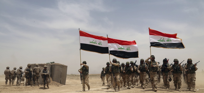 U.S. soldiers, left, participate in a training mission with Iraqi army soldiers outside Baghdad, Iraq, Wednesday, May 27, 2015.