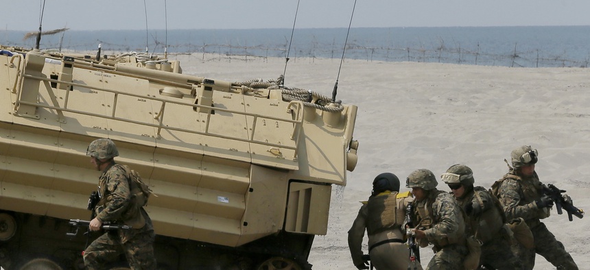 U.S. troops disembark from their amphibious assault vehicle during a combined assault exercise at a beach facing one of the contested islands off the South China Sea known as Scarborough Shoal in the West Philippine Sea on Tuesday, April 21, 2015.