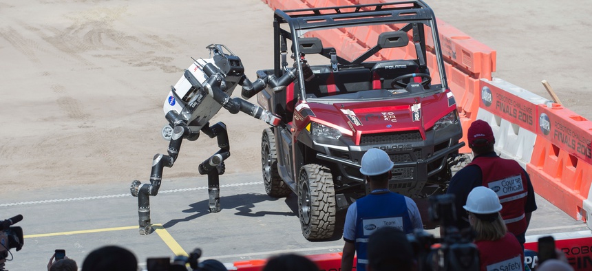 RoboSimian, a simian-inspired robot from the Jet Propulsion Labs, exits a vehicle during the Defense Advanced Research Projects Agency (DARPA) Robotics Challenge (DRC) June 5 in Pomona, Calif.