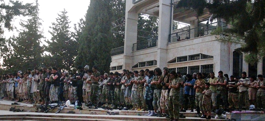 Fighters from the Islamic State group pray at the Tabqa air base after capturing it from the Syrian government in Raqqa, Syria, in August 2014.