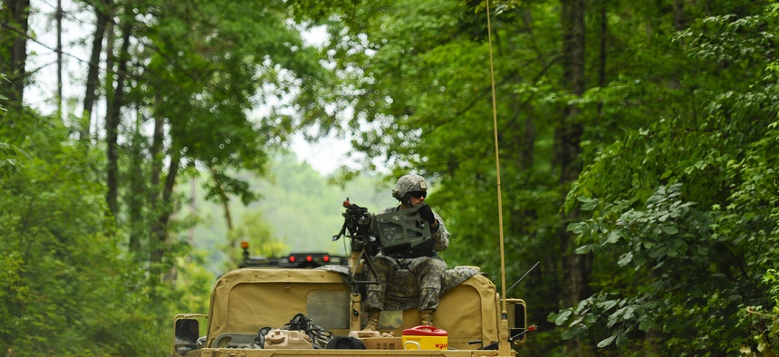 A soldier, assigned to 1221st Route Clearance Company, South Carolina Army National Guard, gunner on top a HMMVV scans for threats during route clearance operations at McCrady Training Center, Eastover, S.C., June 24, 2014.