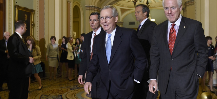 Senate Majority Leader Mitch McConnell of Ky., second from left, walks to the podium to speak to reporters following the weekly Republican luncheon on Capitol Hill in Washington, Tuesday, June 16, 2015.