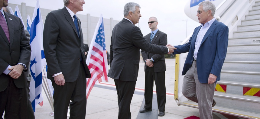 Former Defense Secretary Chuck Hagel shakes hands with Director General of the Israeli Ministry of Defense Udi Shani, as former Israeli Ambasssador to the U.S. Michael Oren looks on.