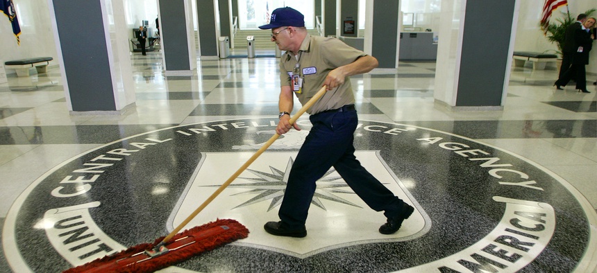 A workman quickly slides a dustmop over the floor at the Central Intelligence Agency headquarters during a visit by President George W. Bush, on March 3, 2005.