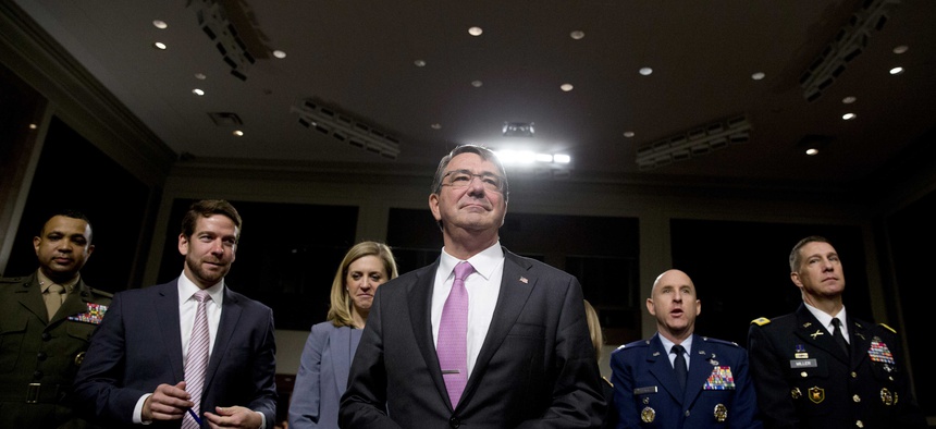 Defense Secretary Ash Carter stands by his seat as he arrives at the Senate Armed Services Committee hearing on Capitol Hill in Washington, Tuesday, July 7, 2015.