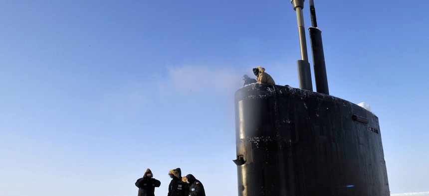 Members of the Applied Physics Laboratory Ice Station clear ice from the hatch of the Los Angeles-class submarine USS Annapolis after the sub broke through the ice while participating in Ice Exercise 2009 in the Arctic Ocean.