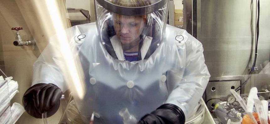 A microbiologist at Life Sciences Test Facility at Dugway Proving Ground, Utah, works in a specialized airtight enclosure designed for use with deadly agents.