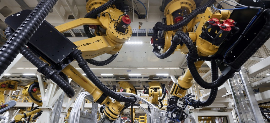 n this Nov. 11, 2014 file photo, robots install rivets on a 2015 Ford F-150 truck at the Dearborn Truck Plant in Dearborn, Mich.