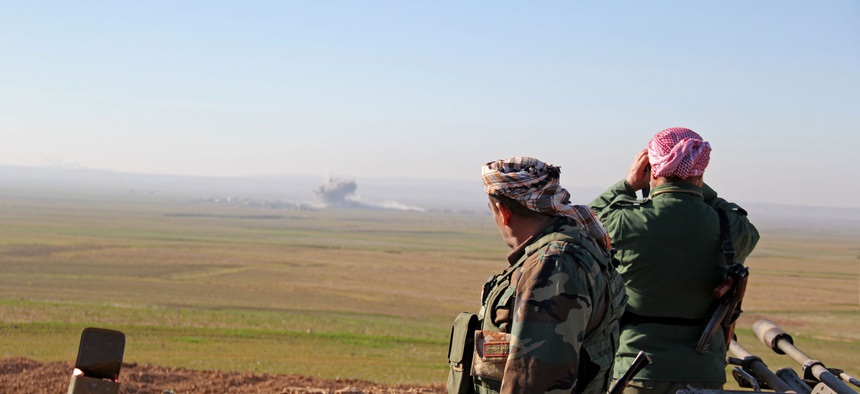 In this Tuesday, Jan. 20, 2015 image released by the Kurdistan Region Security Council (KRSC), Kurdish peshmerga forces watch smoke rise as fighters target Islamic State group positions in northern Iraq.