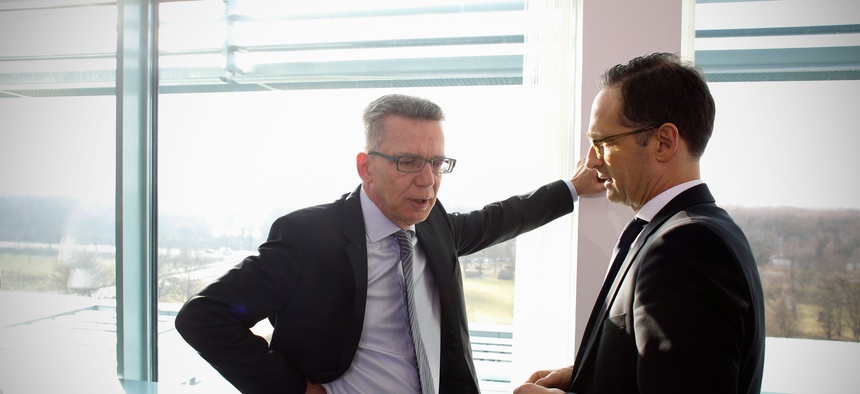 Interior Minister Thomas de Maiziere, left, talks to Justice Minister Heiko Maas prior to the cabinet meeting at the chancellery in Berlin, Germany, Wednesday, Feb. 25, 2015.