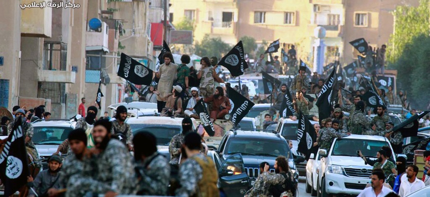 Photo from the Raqqa Media Center of the Islamic State group, a Syrian opposition group, fighters from the Islamic State group parade in Raqqa, north Syria.