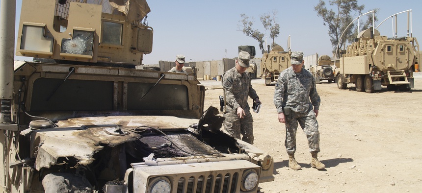 A humvee damaged by an EFP is looked over at the U.S. Army Patrol Base of the 2-28 Infantry in Al Hillah, 62 miles south of Baghdad.