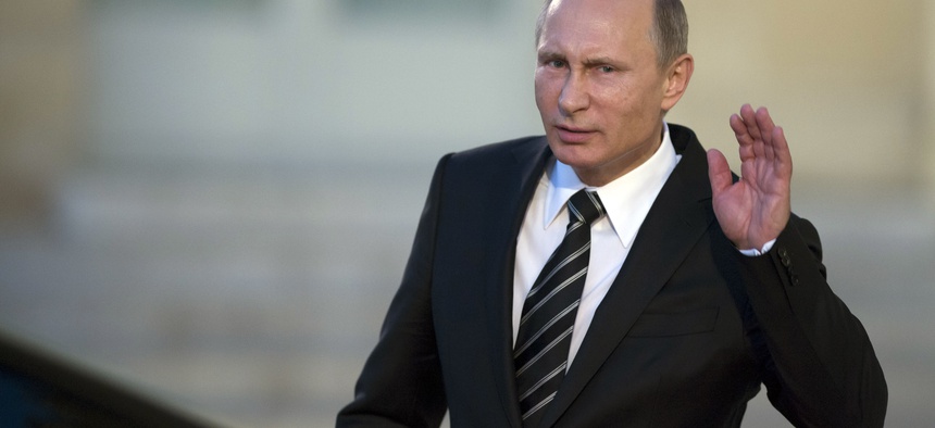 Russian President Vladimir Putin holds his hand on his ear while listening to a newsman’s question as he leaves the Elysee Palace in Paris, France. Friday, Oct. 2 , 2015.