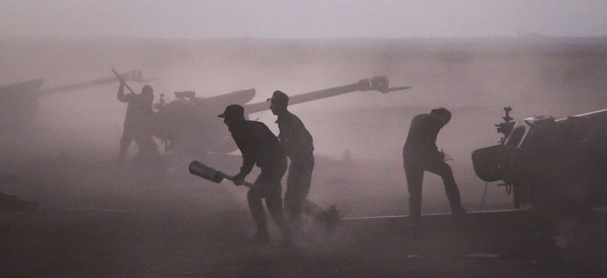 After launching new offensives under Russian air cover, Syrian army personnel load howitzers near the village of Morek in Syria, Oct. 7, 2015