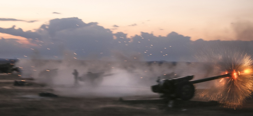 In this photo taken on Wednesday, Oct. 7, 2015, Syrian army howitzers fire near the village of Morek in Syria.