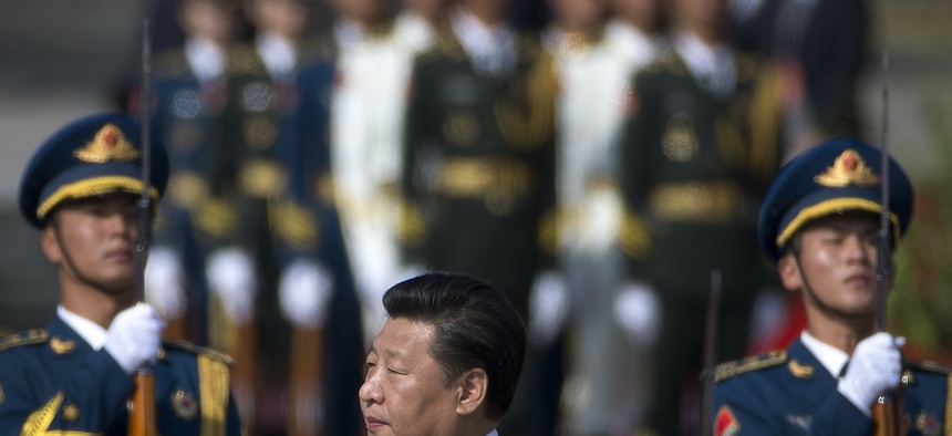Chinese President Xi Jinping, center, walks past guard of honor while visiting the Monument to the People's Heroes during a ceremony marking Martyr’s Day at Tiananmen Square in Beijing, China Wednesday, Sept. 30, 2015.