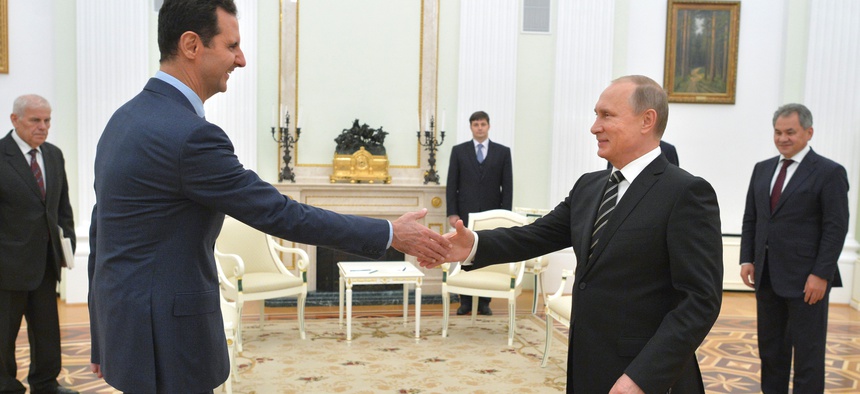 n this photo taken on Tuesday, Oct. 20, 2015, Russian President Vladimir Putin, right, shakes hand with Syrian President Bashar Assad in the Kremlin in Moscow, Russia.