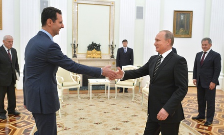 n this photo taken on Tuesday, Oct. 20, 2015, Russian President Vladimir Putin, right, shakes hand with Syrian President Bashar Assad in the Kremlin in Moscow, Russia.