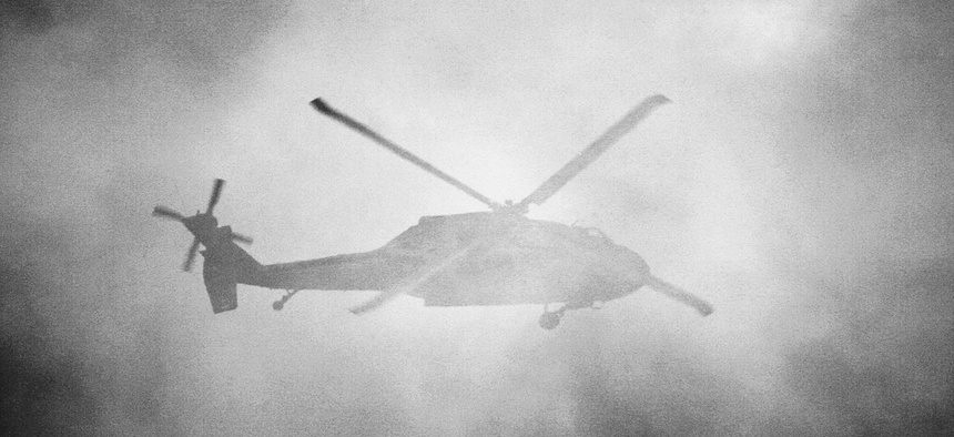 A United States Army Sikorsky UH-60 Blackhawk flies behind a cloud of smoke during the Combined Arms Demonstration at the Rhode Island National Guard Open House and Airshow, held at Quonset State Airport (KOQU/OQU) in North Kingstown, RI.
