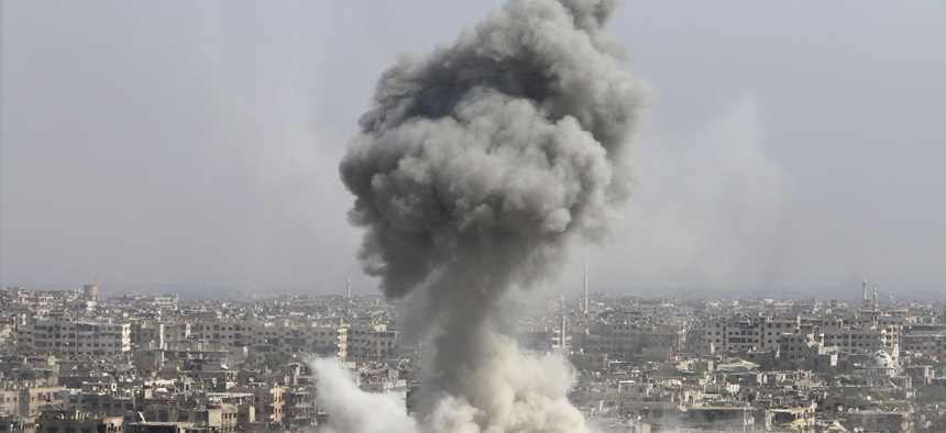 In this photo taken on Wednesday, Oct. 14, 2015, smoke rises after shelling by the Syrian army in Jobar, Damascus, Syria.