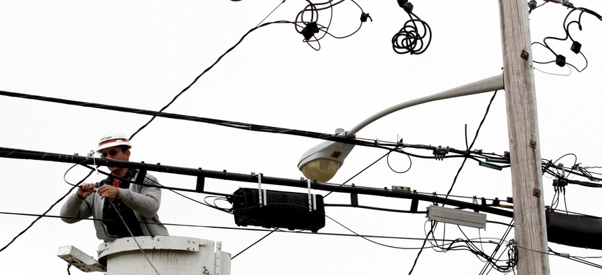 Verizon lineman Joe DeBonis connects fiber optic cable that will serve a home in North Bellmore, N.Y. in a file photo from May 11, 2006.