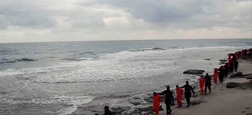 In this file image made from a video released Sunday, Feb. 15, 2015 by militants in Libya claiming loyalty to the Islamic State group purportedly shows Egyptian Coptic Christians in orange jumpsuits being led along a beach.