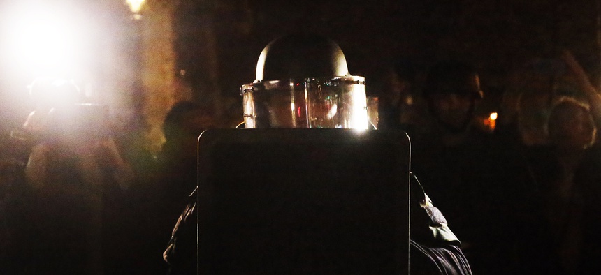 French police in full bulletproof gear returns after a false alert, sent hundreds running off the place de la Republique in Paris, France, Sunday Nov. 14, 2015.