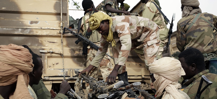 Chadian soldiers collect weapons seized from Boko Haram fighters in the Nigerian city of Damasak, Nigeria, Wednesday March 18, 2015.