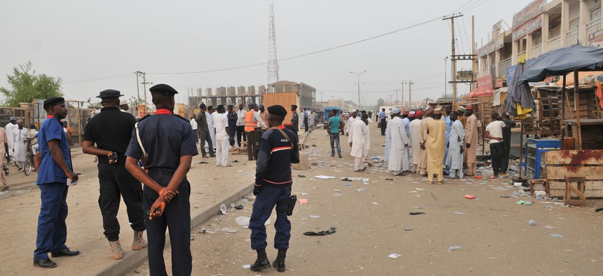 Security officers stand guard at the scene of an explosion at a mobile phone market in Kano, Nigeria.