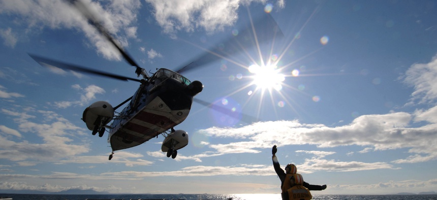 ATLANTIC OCEAN (April 23, 2012) Seaman Apprentice Pedro Deleon, front, communicates to the pilots of a Royal British navy helicopter using hand signals as they take off from the flight deck aboard the guided-missile destroyer USS Forrest Sherman (DDG 98).