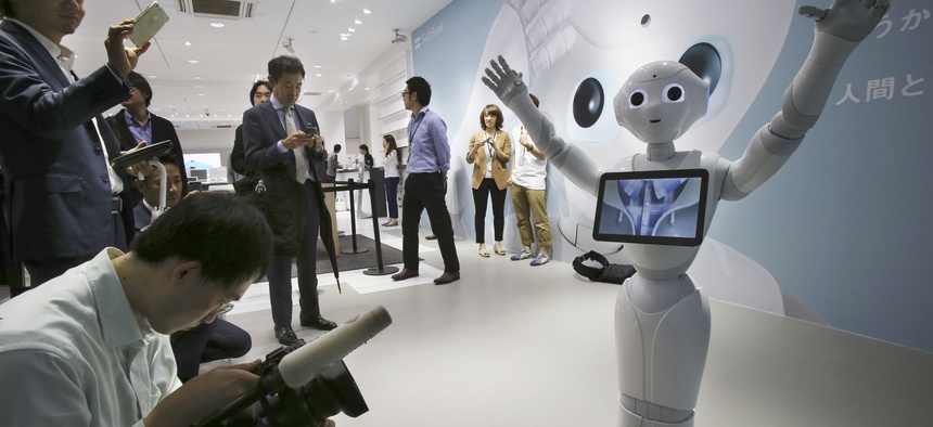 In this June 6, 2014 file photo, journalists surround humanoid robot Pepper on display at SoftBank Mobile shop in Tokyo. Japanese mobile carrier Softbank said Tuesday, Feb. 10, 2015.