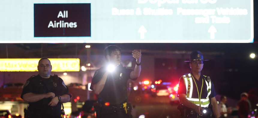 Officers stand at the entrance to New Orleans International Airport, Friday, March 20, 2015, in Kenner, La.