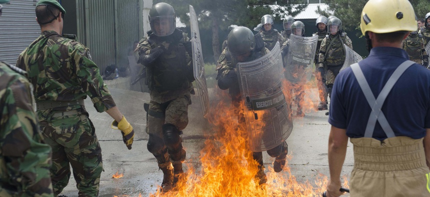 Italian soldiers move as a team through a molotov cocktail during fire phobia training at Camp Slim Lines July 25, 2013.