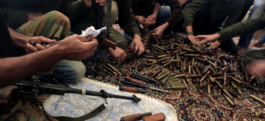 In this Wednesday, Nov. 14, 2012 file photo, Free Syrian Army fighters clean their weapons and check ammunition at their base on the outskirts of Aleppo, Syria.