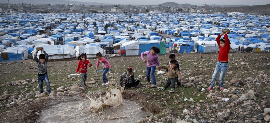 In this Saturday, Nov. 28, 2015 photo, Syrian refugee children play at a temporary refugee camp in Irbil, northern Iraq.